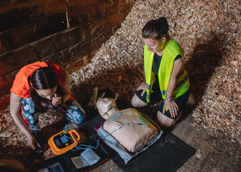 Dvě ženy nasazují AED na recusitační figurínu